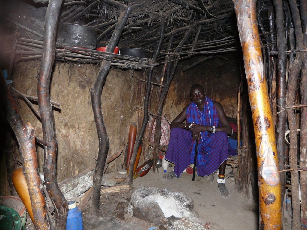 Maasai in his boma house by Rich Clampitt