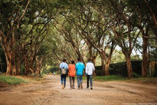 Tanzania teenagers walking under African trees